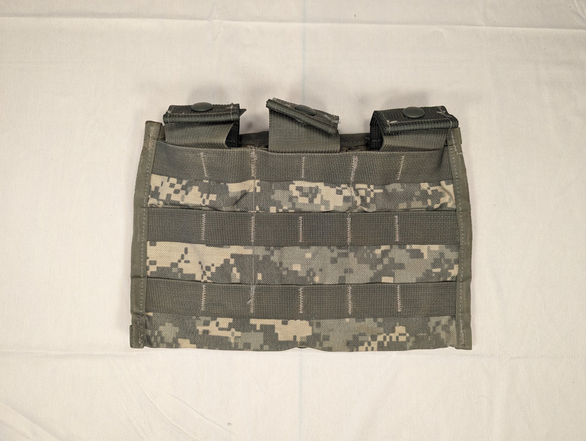 A single U.S. Military Surplus Triple Magazine Pouch in ACU digital camouflage, laid flat, displaying the three vertical magazine slots and dense horizontal MOLLE webbing on the front.