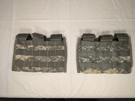 A studio shot of two U.S. Military Surplus Triple Magazine Pouches in ACU digital camouflage, laid flat, featuring dense horizontal MOLLE webbing and webbing strap closures at the top.