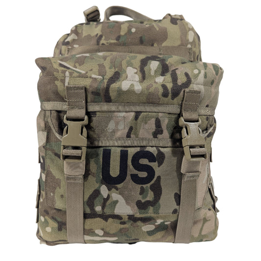 A U.S. Military Surplus 3-Day Assault Pack in OCP/Multicam camouflage, standing upright, featuring a large stenciled 'US' mark, quick-release buckle closures, and horizontal MOLLE webbing.