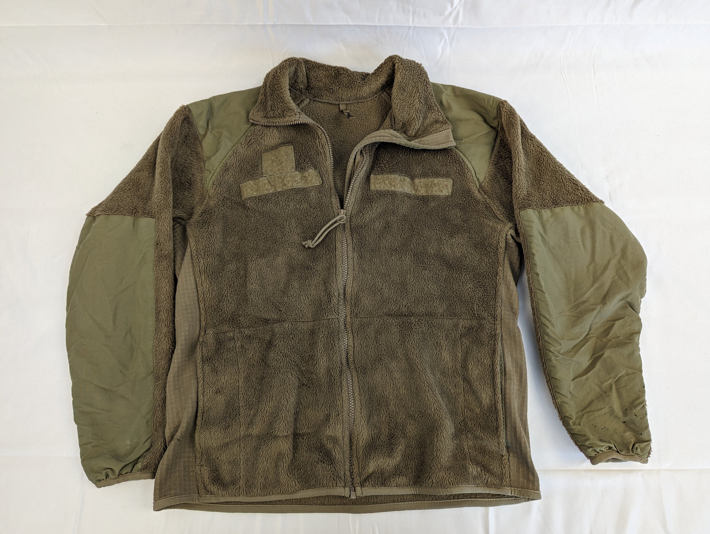 A U.S. Military Cold Weather Fleece Jacket in Coyote Brown laid flat, displaying the front view, the full-length zipper, and reinforced nylon panels on the shoulders and arms.