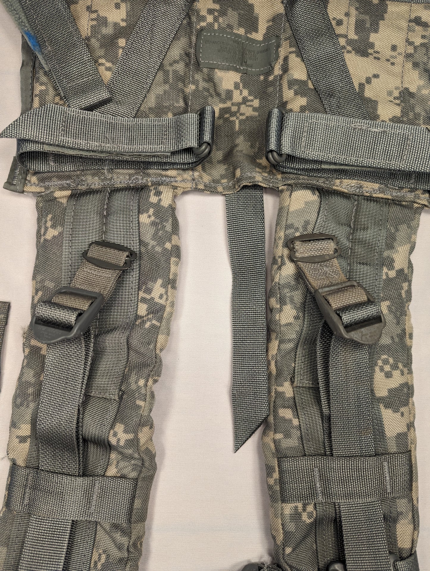A close-up view of a pair of U.S. Military Surplus Enhanced Frame Shoulder Straps in ACU digital camouflage, laid side-by-side, highlighting the padded construction, webbing adjusters, and plastic buckles.