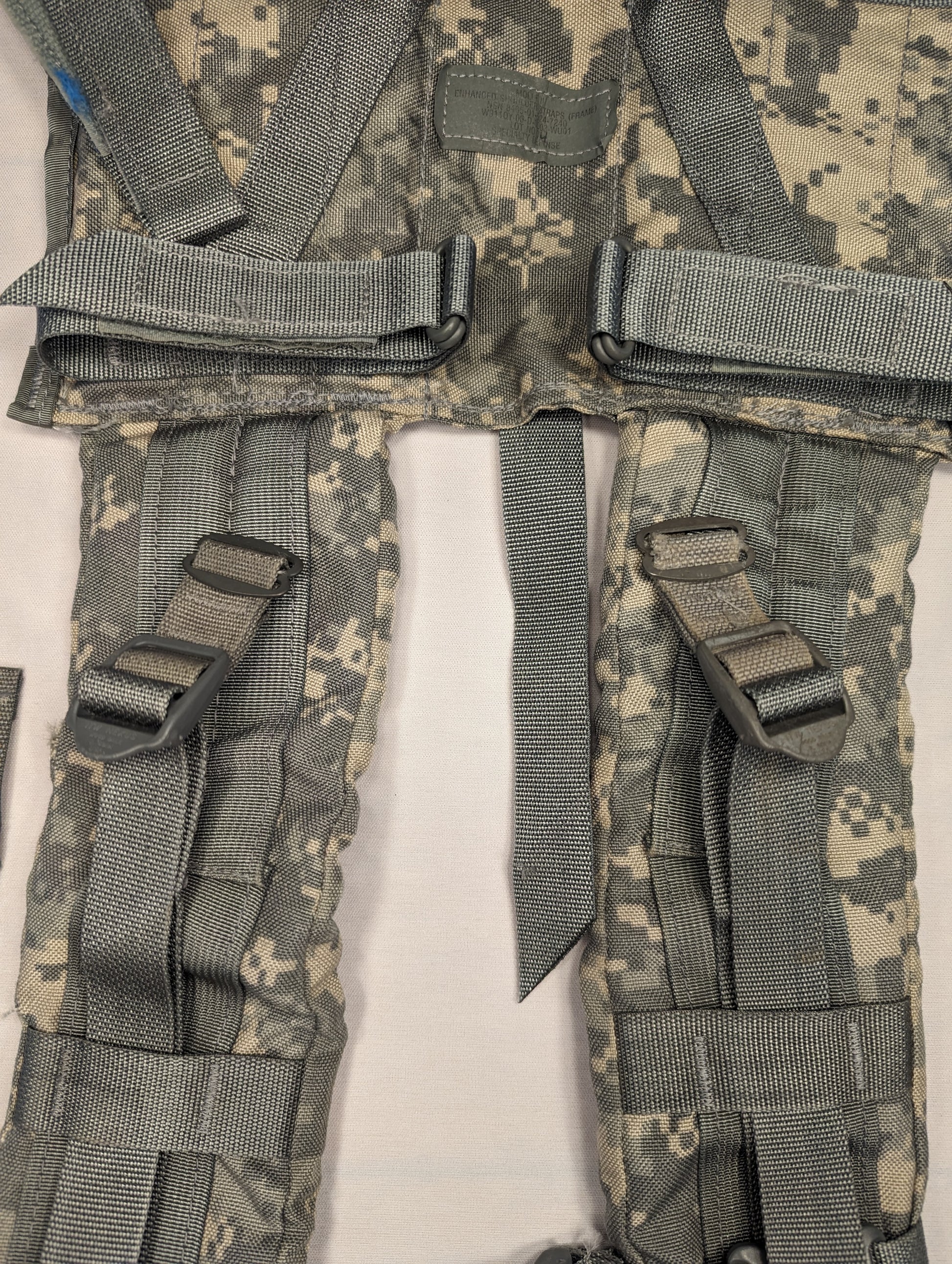 A close-up view of a pair of U.S. Military Surplus Enhanced Frame Shoulder Straps in ACU digital camouflage, laid side-by-side, highlighting the padded construction, webbing adjusters, and plastic buckles.