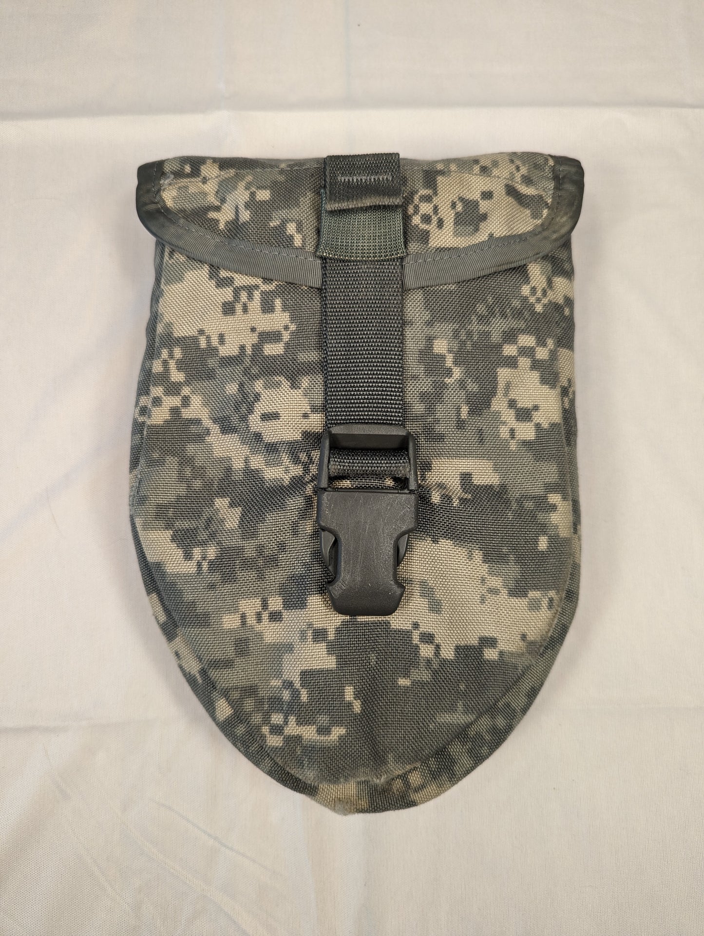 A single U.S. Military Surplus Entrenching Tool Carrier pouch in ACU digital camouflage, standing upright on a white background, with the flap closed and secured by a black quick-release buckle.