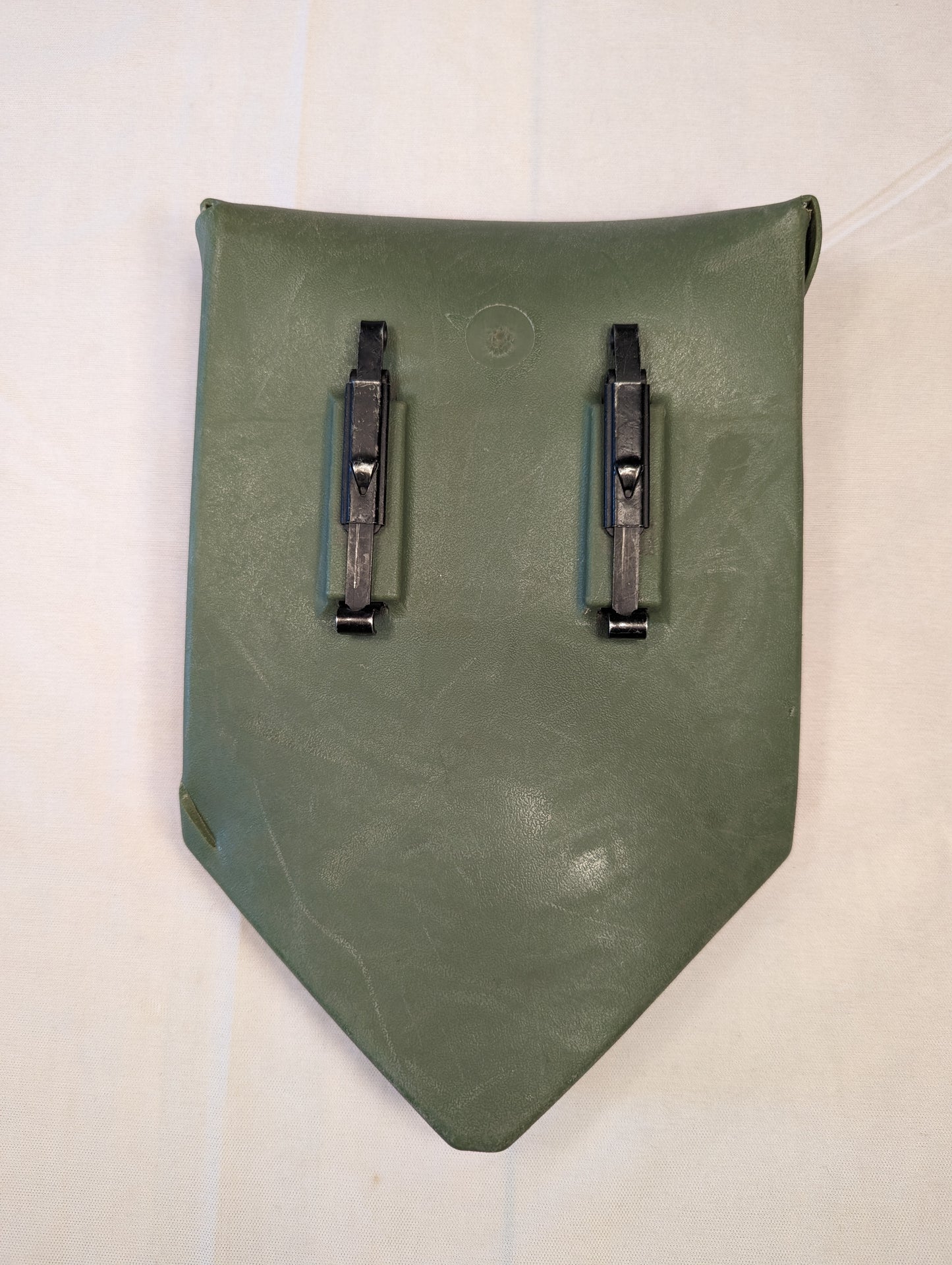 A back view of a single U.S. Military Surplus plastic entrenching tool carrier case in olive drab green, displaying the two black metal ALICE attachment clips.