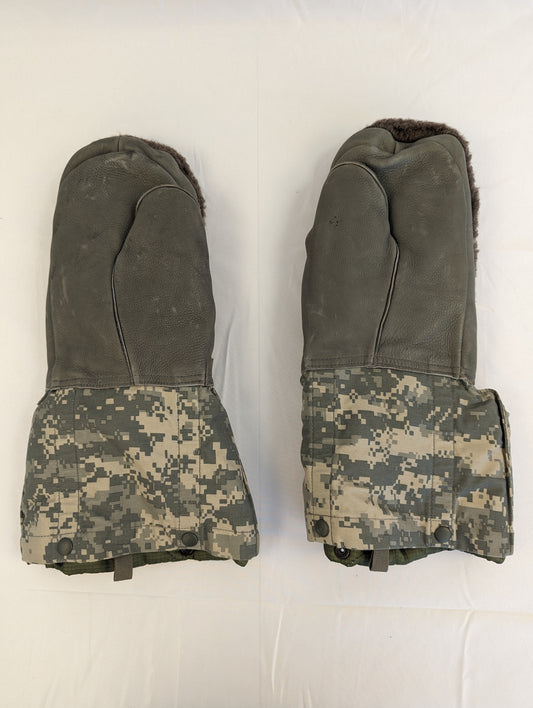 A pair of U.S. Military Extreme Cold Weather Mittens laid flat, featuring a dark olive suede palm and back with ACU digital camouflage cuffs and thick fur lining visible.