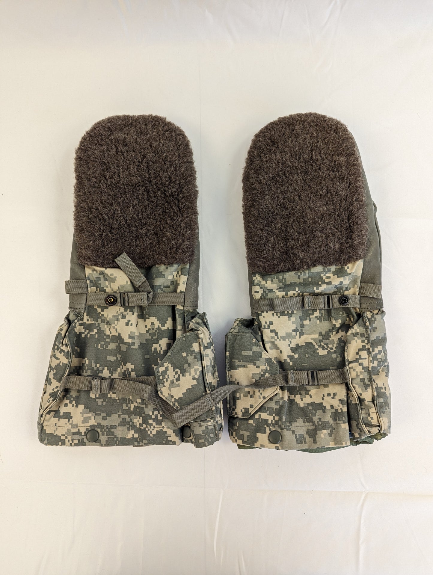 A pair of U.S. Military Extreme Cold Weather Mittens laid flat, featuring a dark olive suede palm and back with ACU digital camouflage cuffs and thick fur lining visible.