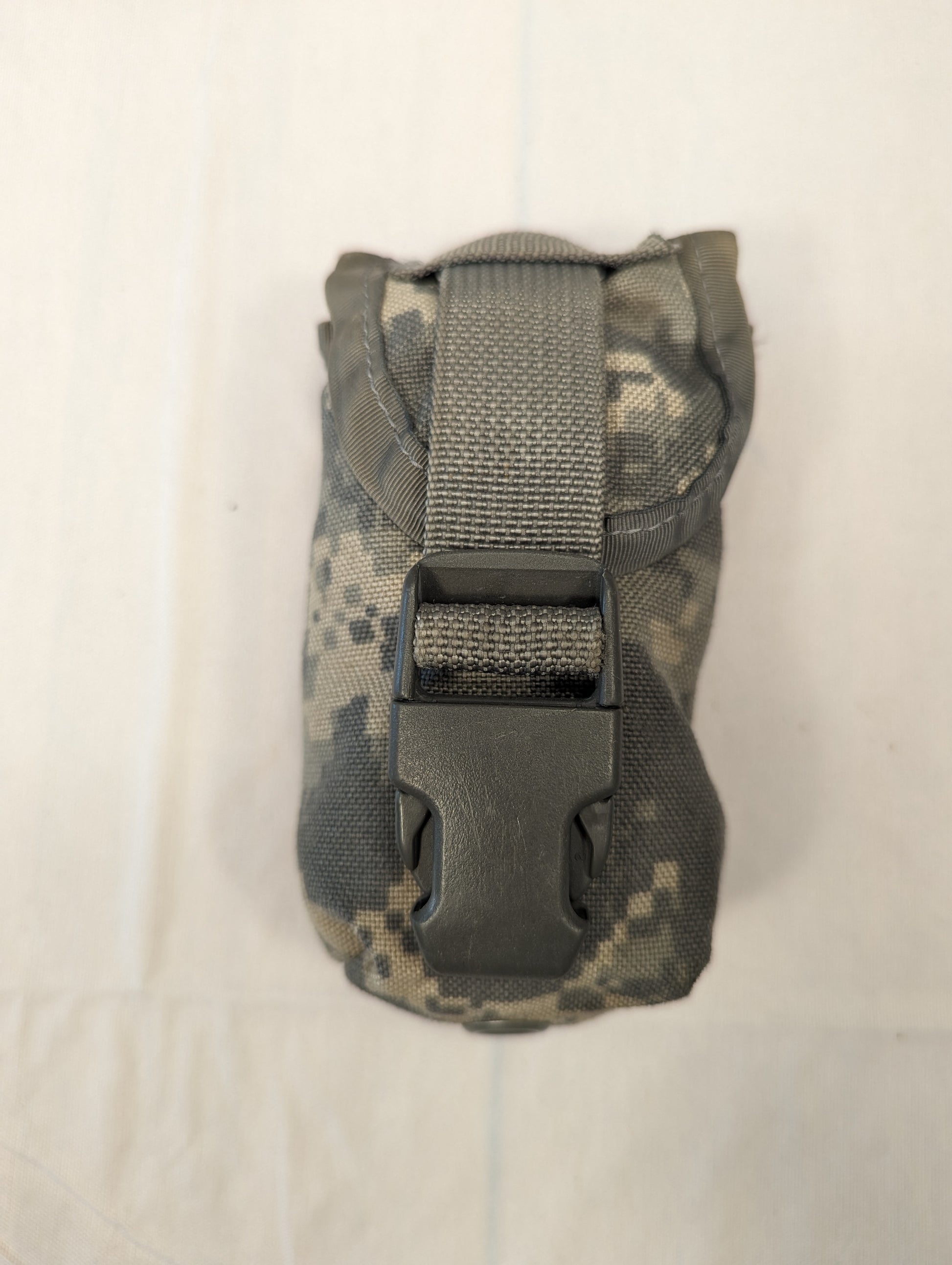 A single U.S. Military Surplus FG Pouch in ACU digital camouflage, standing upright, featuring a top flap secured by a gray webbing strap and black quick-release buckle.