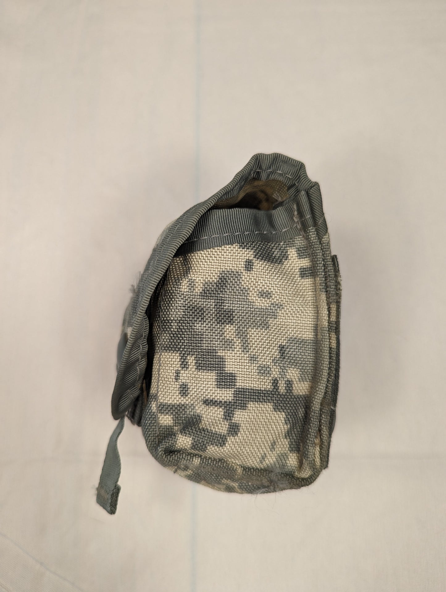 A side profile view of a single U.S. Military Surplus Hand Grenade Pouch in ACU digital camouflage, highlighting the flap closure and the pouch's depth.