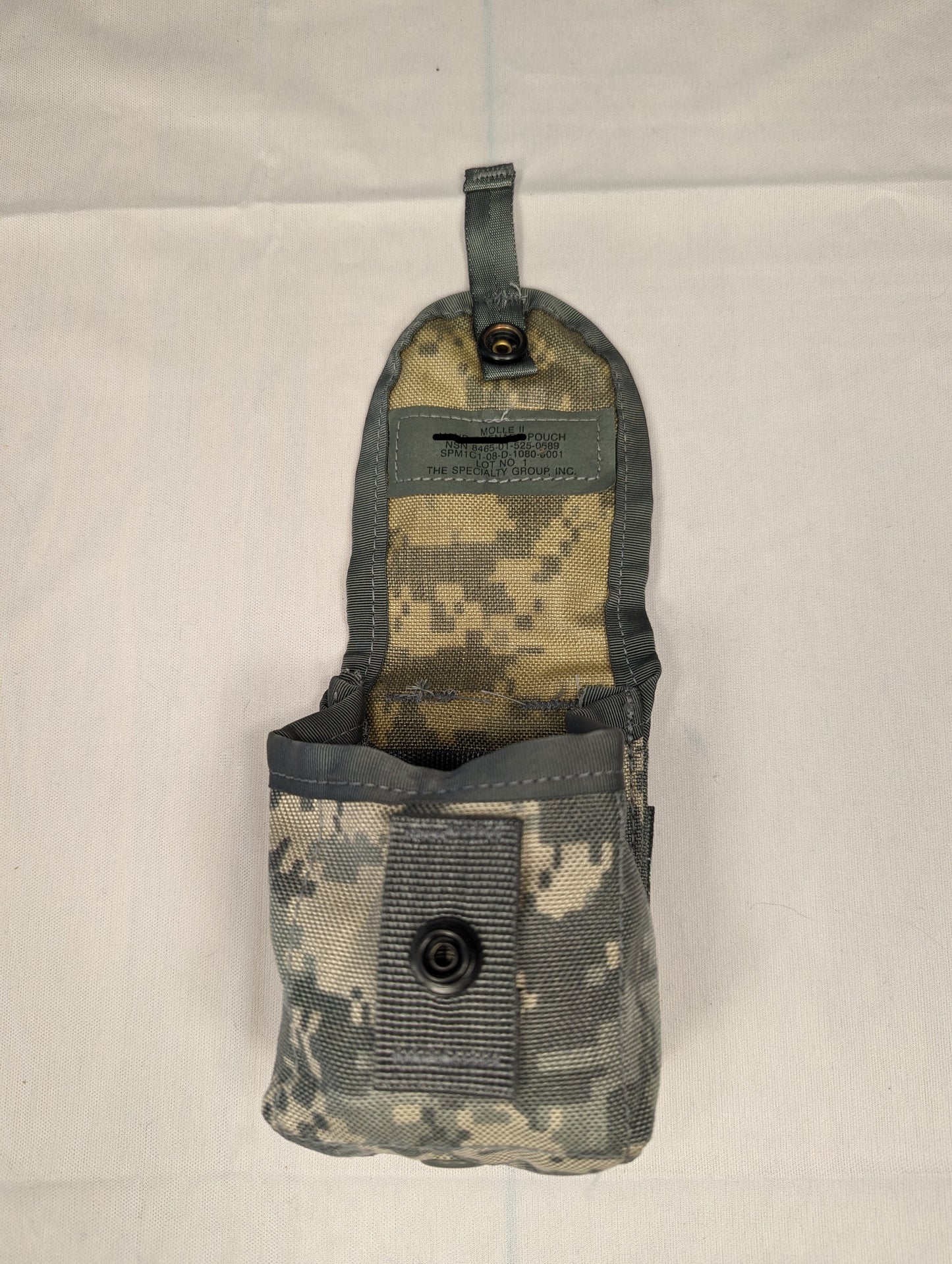 A single U.S. Military Surplus Hand Grenade Pouch in ACU digital camouflage, standing upright with the top flap open, displaying the interior compartment and the official issue tag.