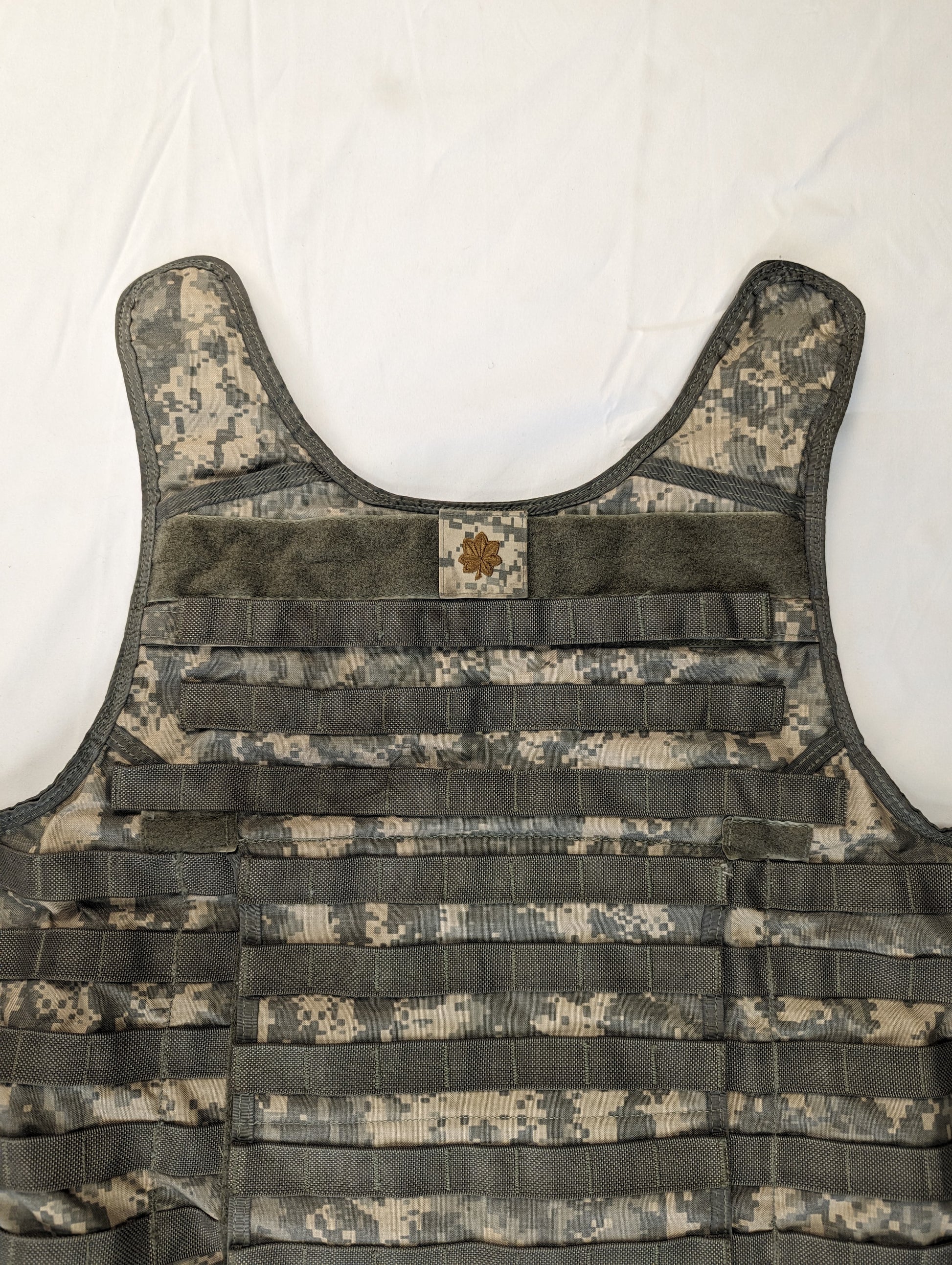 A large Improved Outer Tactical Vest (IOTV) in ACU digital camouflage, displayed flat on a white background, highlighting the MOLLE webbing, hook-and-loop patch field, and quick-release shoulder straps.