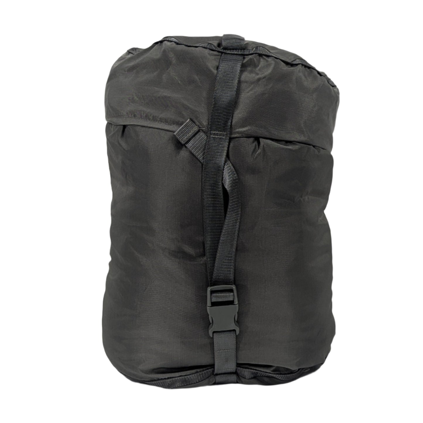 A large, tightly compressed U.S. Military Surplus Compression Stuff Sack in black, featuring heavy-duty black webbing straps and buckles, isolated on a white background.