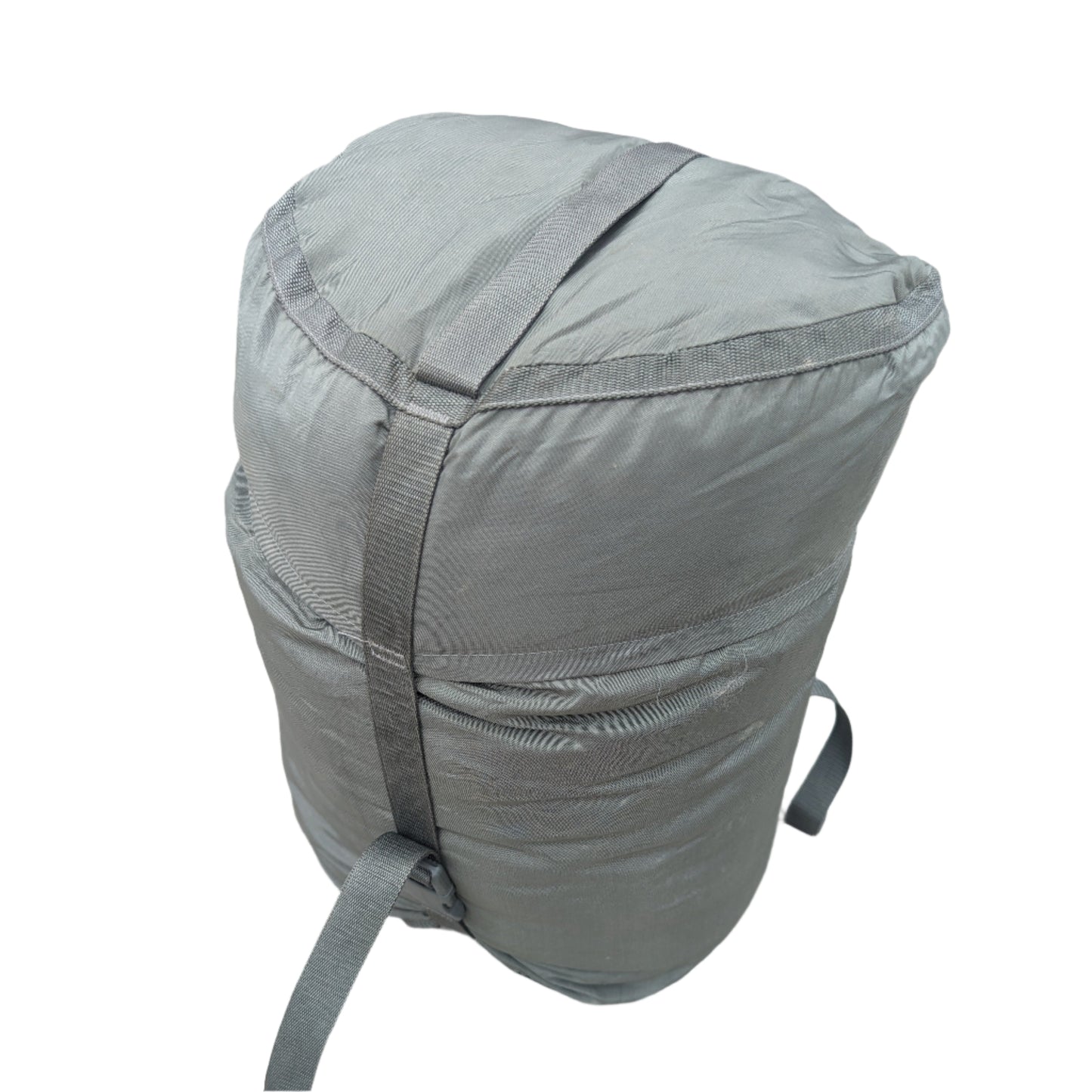 A large, tightly compressed U.S. Military Surplus Compression Stuff Sack in foliage green, featuring heavy-duty vertical and horizontal webbing straps, displayed on a white background.