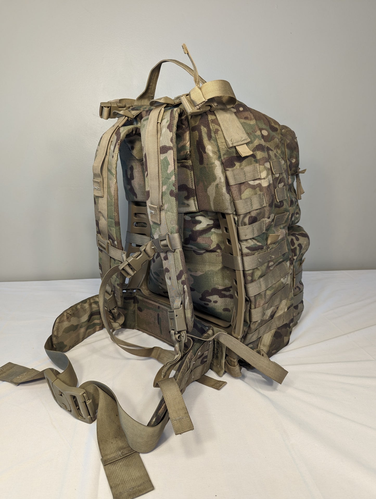 A rear view of a U.S. Military Surplus Medium Field Pack Rucksack in OCP/Multicam camouflage, highlighting the padded shoulder harness, hip belt, and complete suspension system.