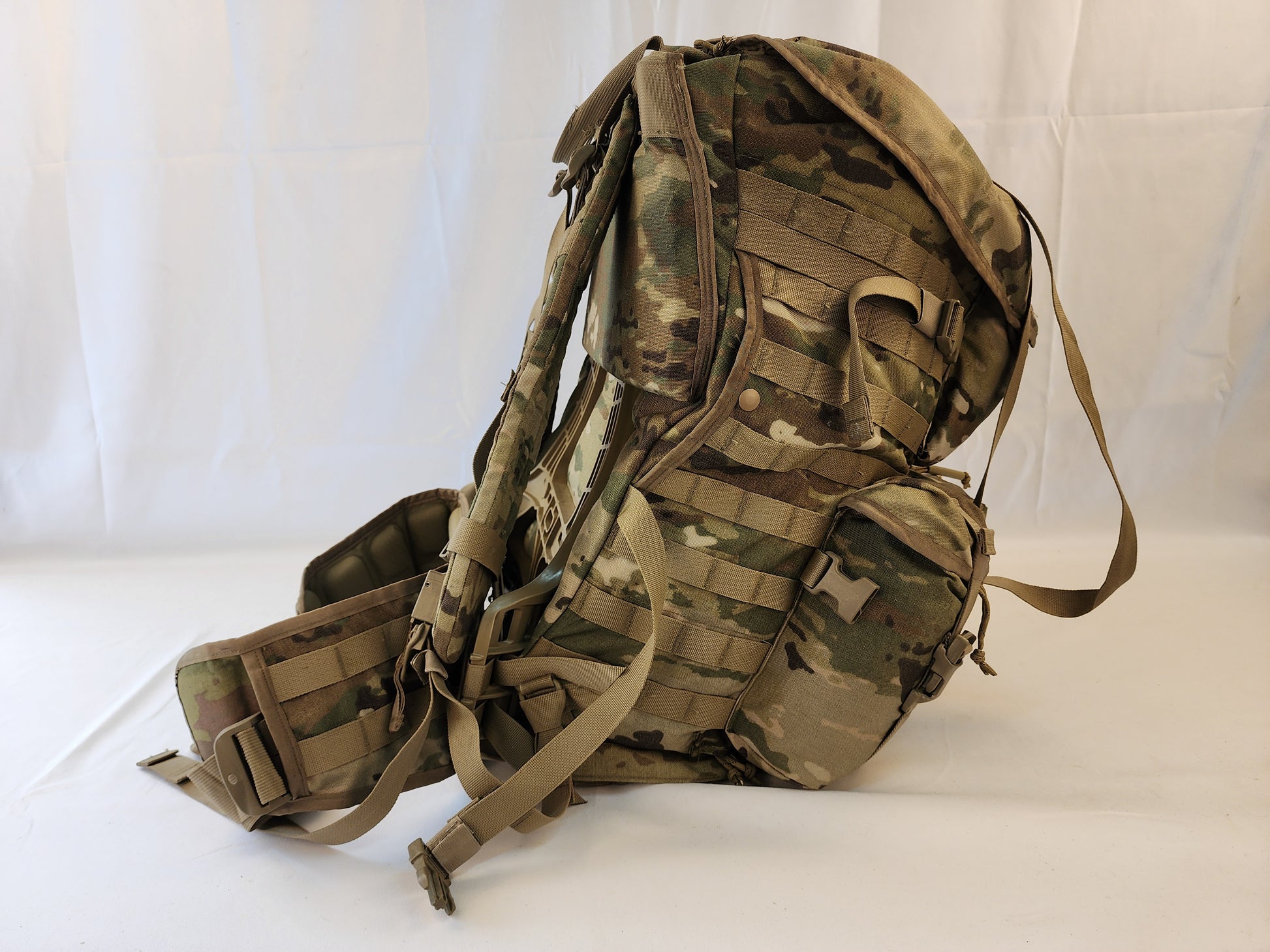 A large U.S. Military Surplus MOLLE 4000 Rucksack in OCP/Multicam camouflage, shown at a three-quarter angle on a white background, highlighting its side pockets, compression straps, and overall profile.