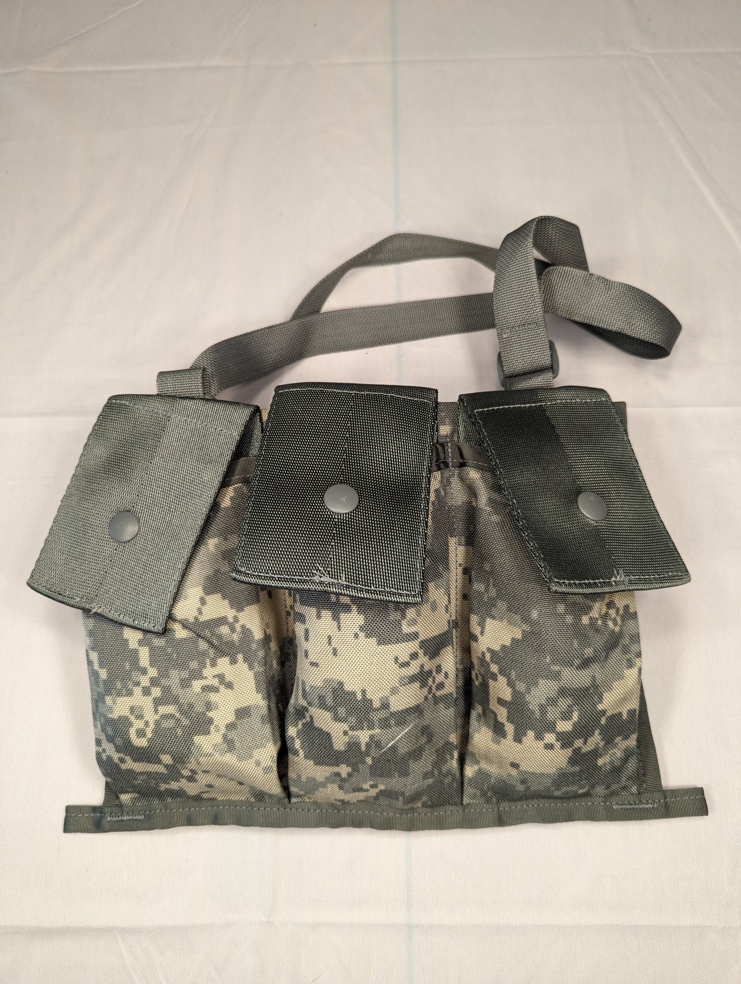A single U.S. Military Surplus MOLLE II Bandoleer in ACU digital camouflage, featuring three vertical magazine pockets with snap-button flaps and an attached shoulder strap.