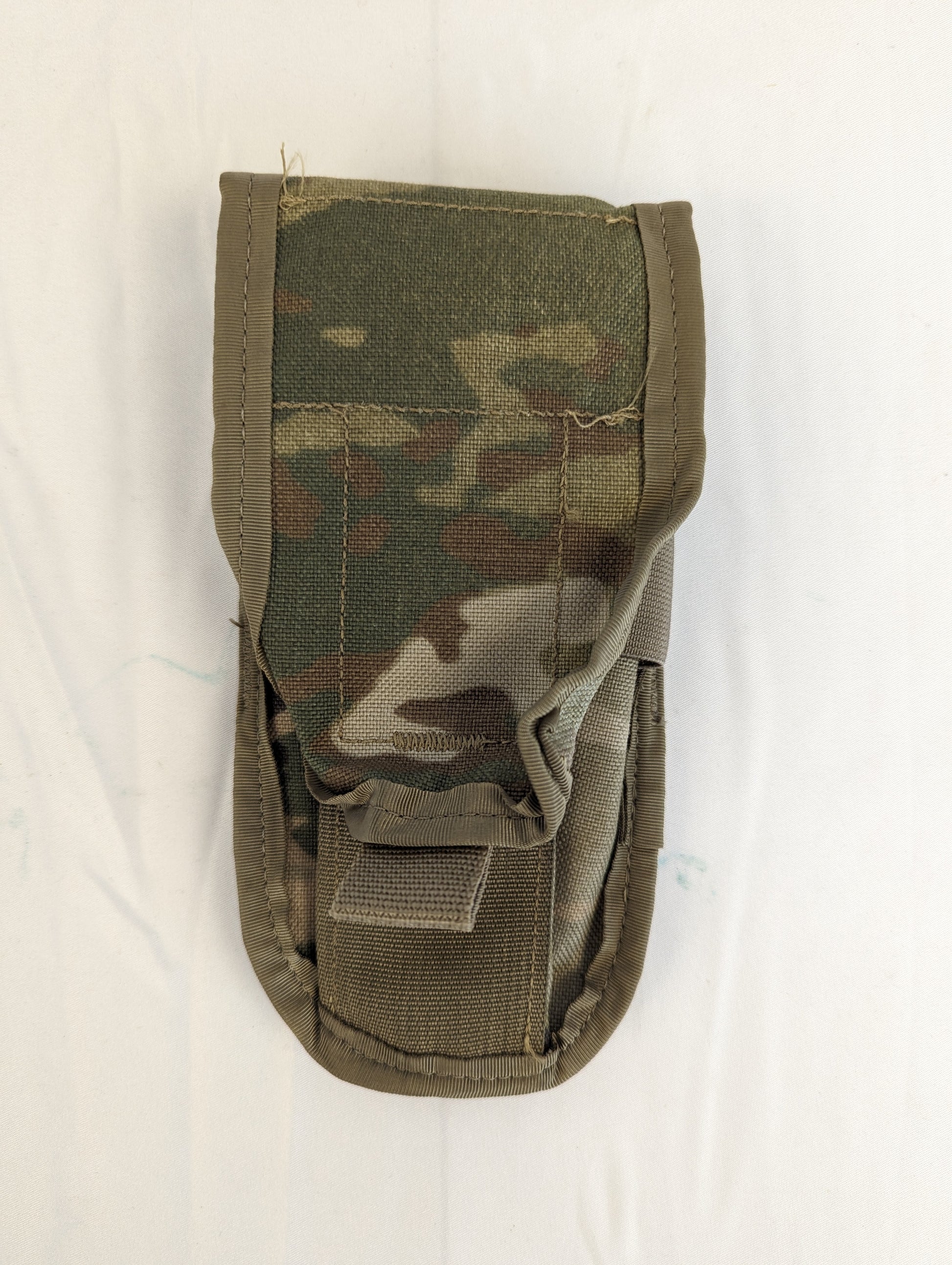 A single U.S. Military Surplus Double Magazine Pouch in OCP/Multicam camouflage, standing upright, featuring a flap closure and elastic retention webbing at the base, displayed on a white background.