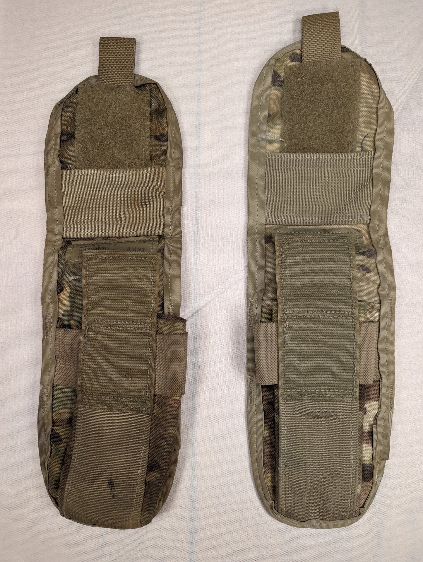 A back view of two U.S. Military Surplus MOLLE II Double Magazine Pouches in OCP/Multicam camouflage, showing the vertical MOLLE attachment straps and horizontal webbing.