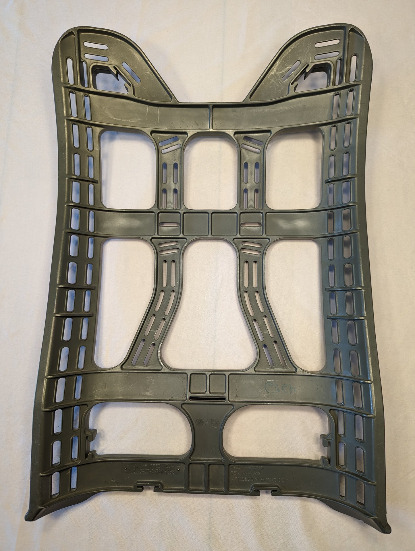 A full front view of a U.S. Military Surplus MOLLE II Enhanced Rucksack Frame in dark olive green, featuring a contoured, rigid plastic design and multiple attachment points, laid flat on a light background.