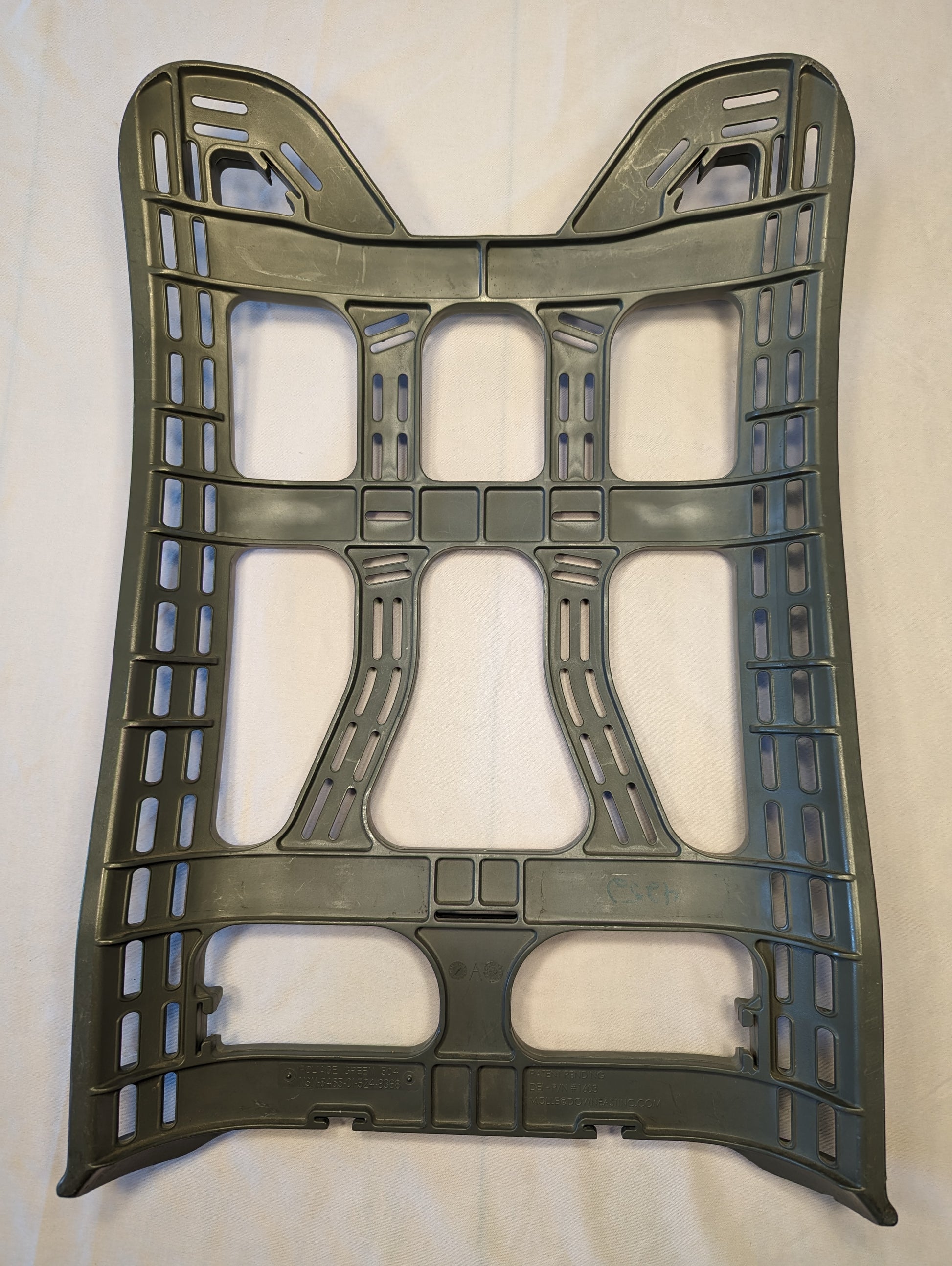 A full front view of a U.S. Military Surplus MOLLE II Enhanced Rucksack Frame in dark olive green, featuring a contoured, rigid plastic design and multiple attachment points, laid flat on a light background.
