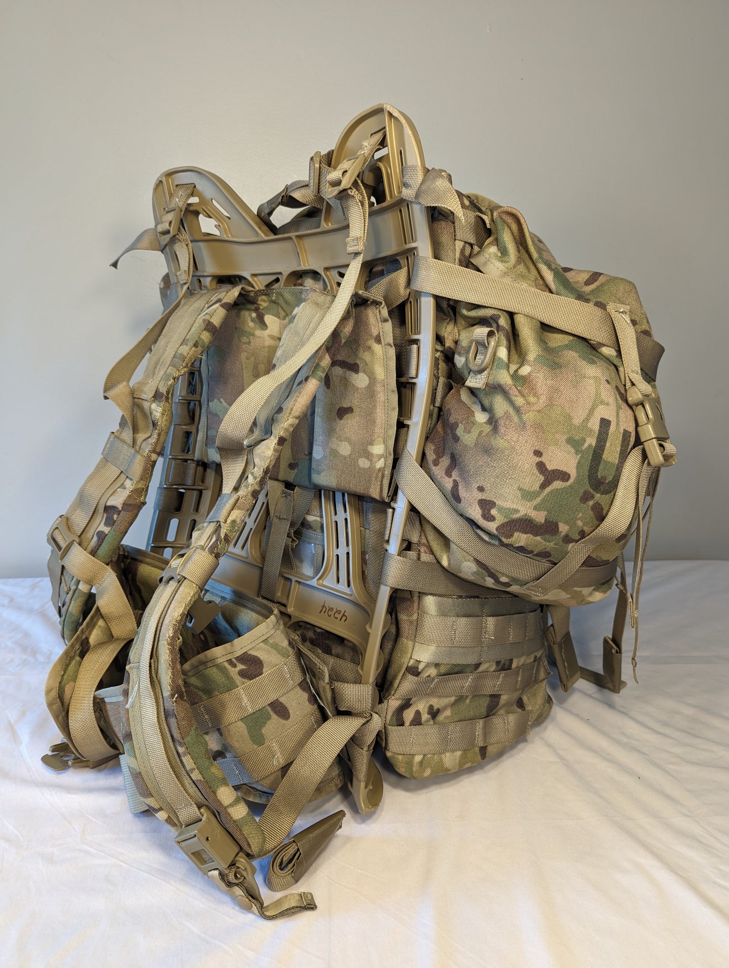A large U.S. Military Surplus MOLLE II Field Pack in OCP/Multicam camouflage, standing upright and fully assembled with multiple attached pouches, complex webbing, and the external frame visible.
