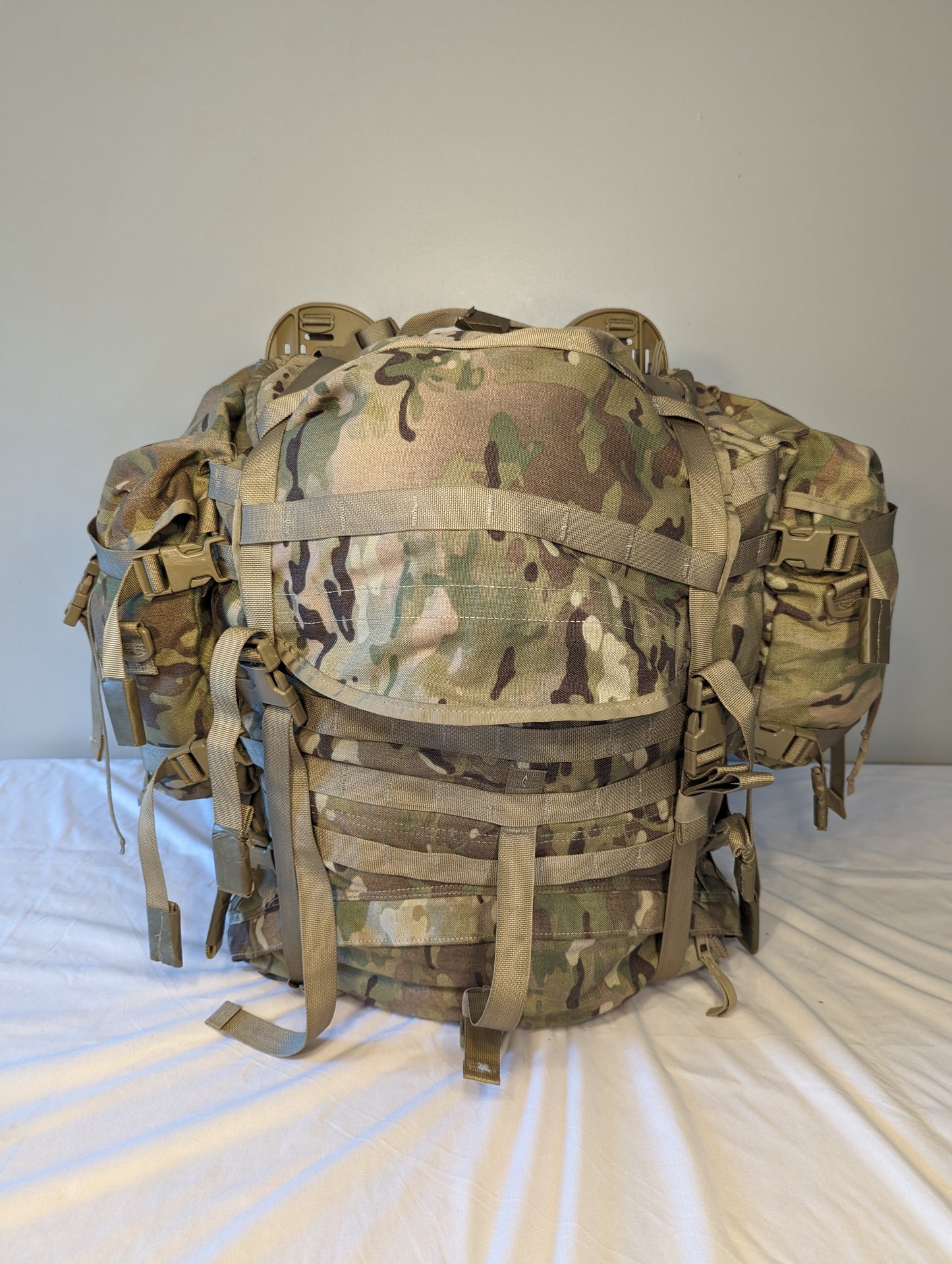 A heavily loaded U.S. Military Surplus Large Field Pack in OCP/Multicam camouflage, fully assembled with multiple side and front pouches, and secured tightly by extensive webbing and buckles.