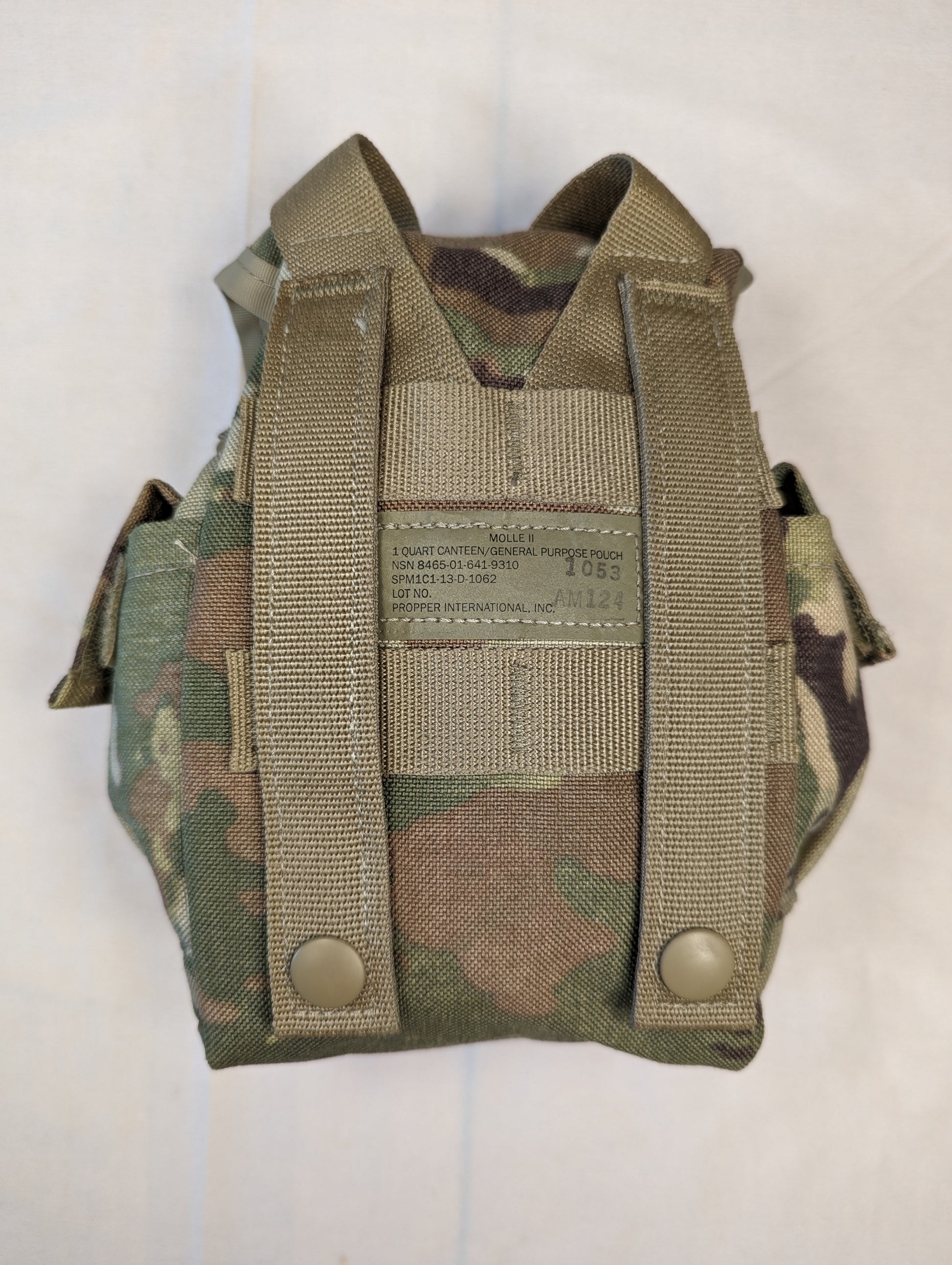 A back view of a U.S. Military Surplus Canteen/General Purpose Pouch in OCP/Multicam camouflage, clearly displaying the two vertical MOLLE attachment straps with snap buttons and a manufacturer's label.
