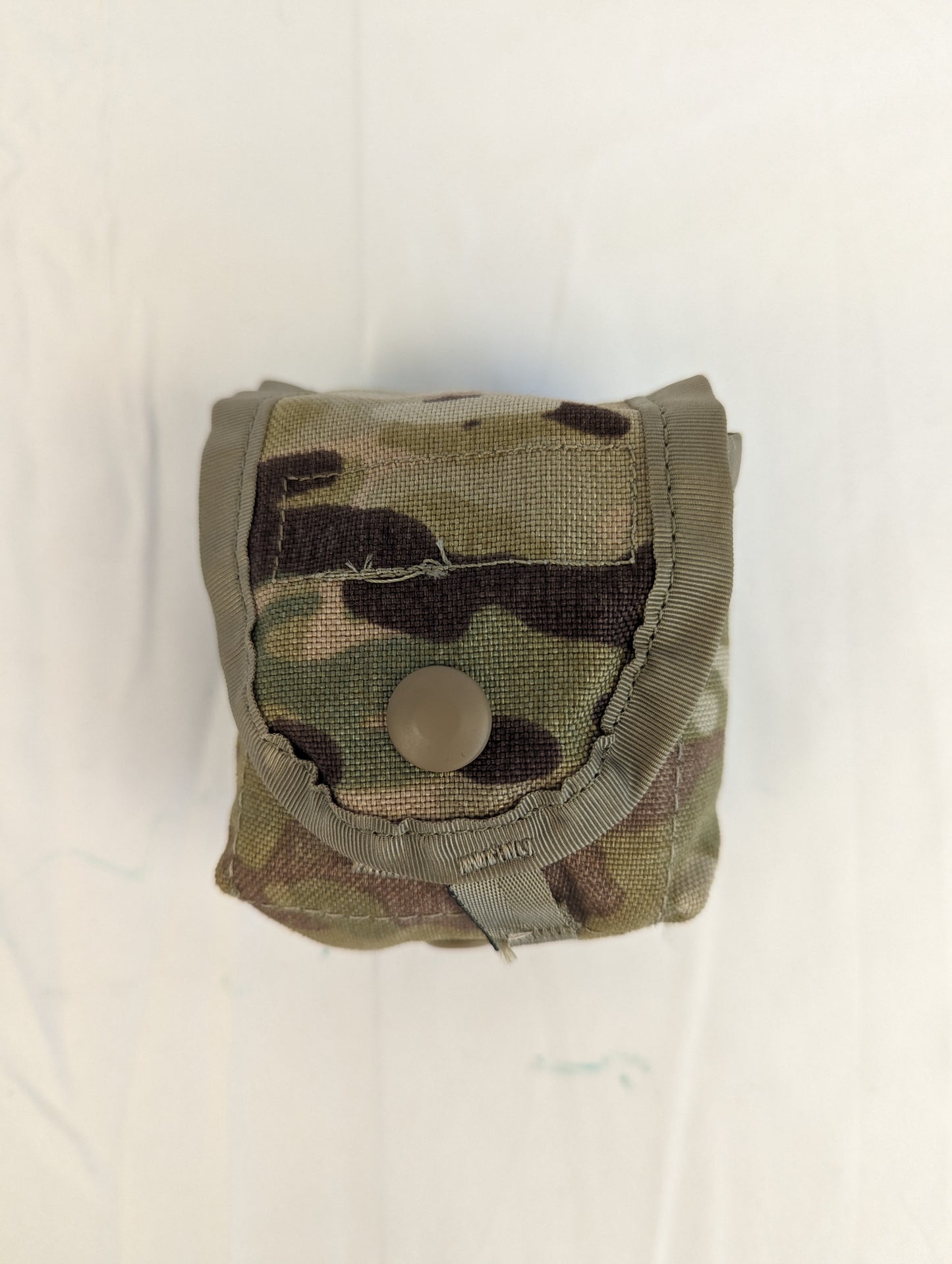 A single U.S. Military Surplus hand grenade pouch in OCP/Multicam camouflage, standing upright and closed with a tan snap button on a white background.