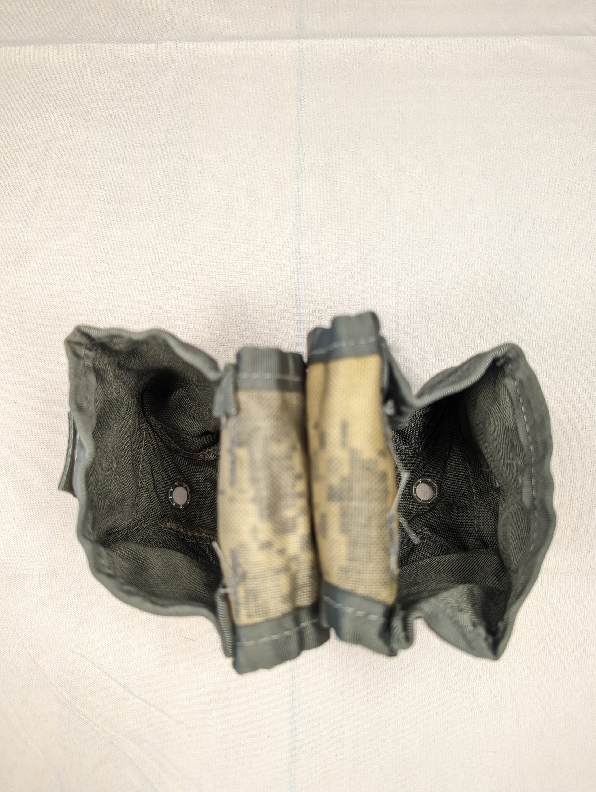 A close-up view of two U.S. Military Surplus Double Magazine Pouches in OCP/Multicam camouflage, shown open to display the three individual internal magazine sleeves in each pouch.