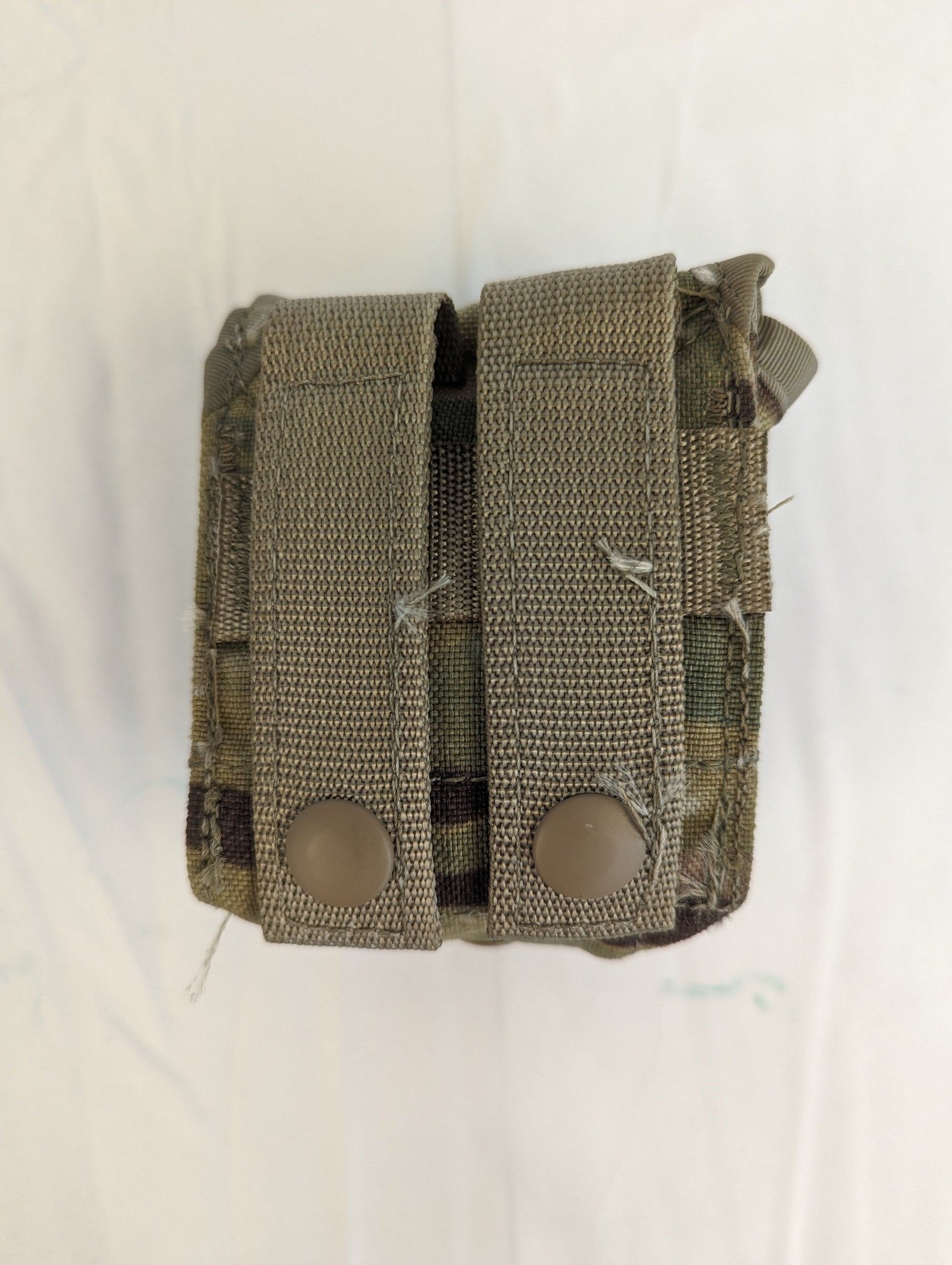 A studio shot of two U.S. Military Surplus Hand Grenade Pouches in OCP/Multicam camouflage, shown side-by-side, each featuring two vertical MOLLE straps and a closed snap-button flap.