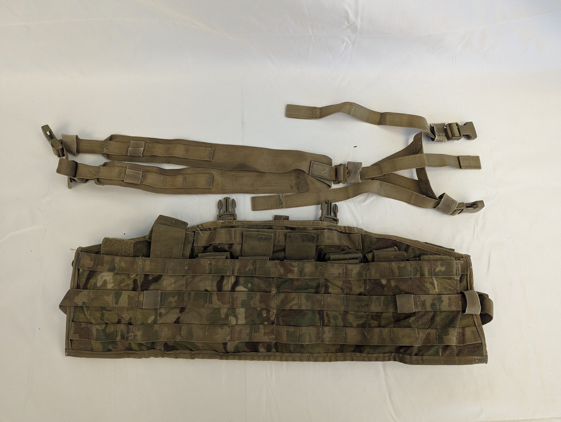 A U.S. Military Surplus Tactical Assault Panel (TAP) in OCP/Multicam camouflage, laid flat and disassembled, showing the adjustable H-harness and the main chest panel with horizontal MOLLE webbing.