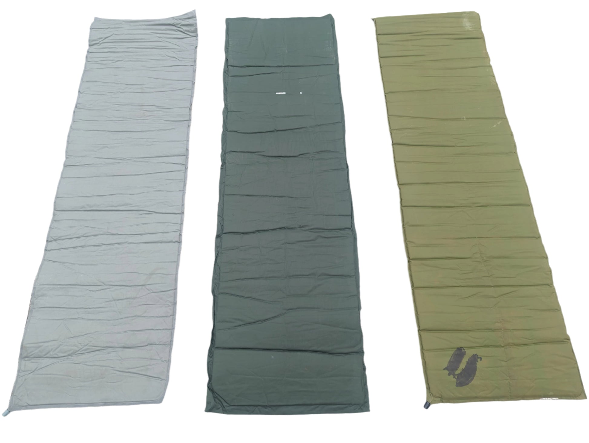 Three U.S. Military surplus self-inflating sleeping mats laid flat side-by-side on a white background, showing color variations in foliage green, dark gray, and olive drab.