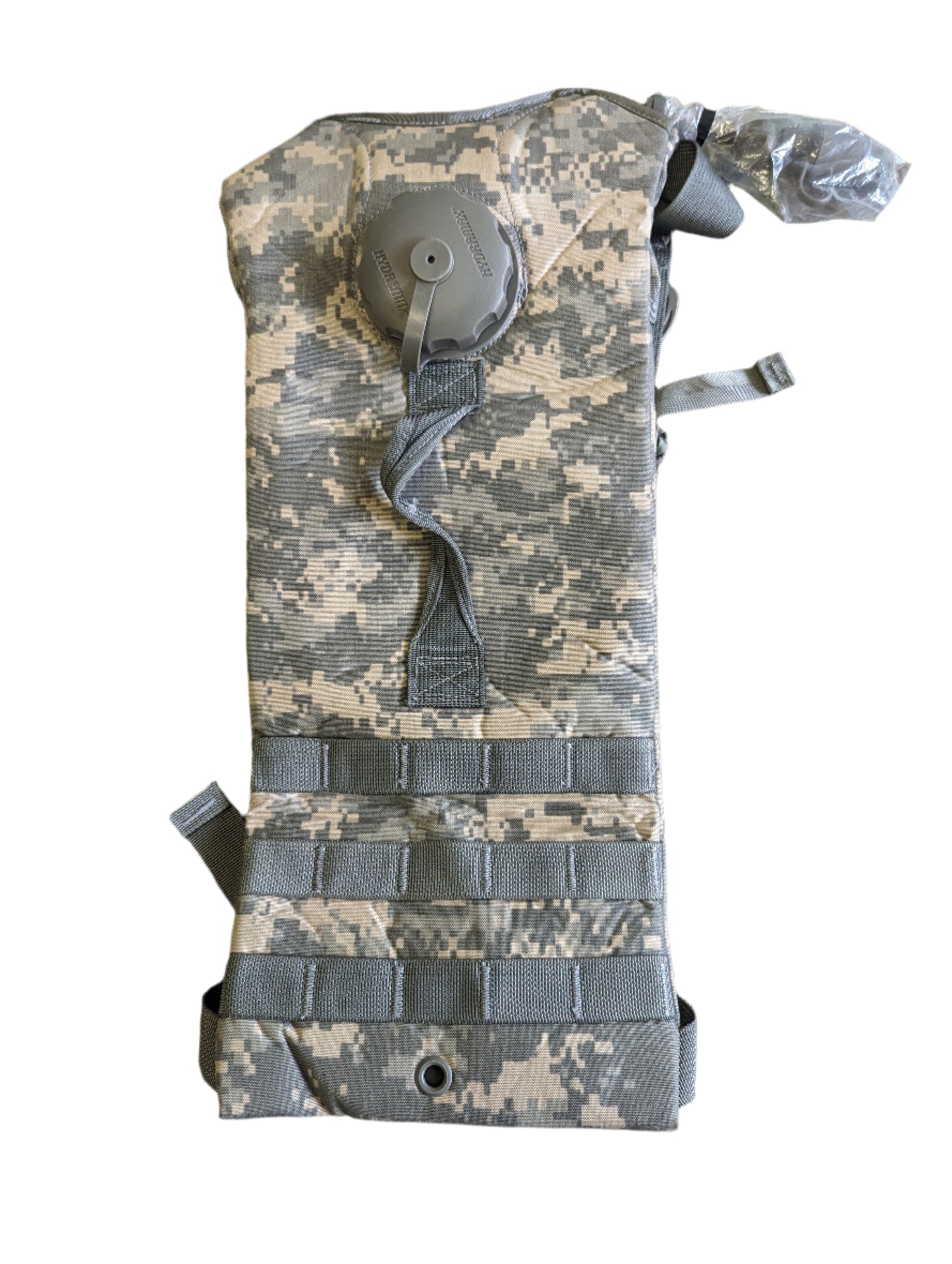 A front view of a U.S. Military Surplus Hydration Carrier in ACU digital camouflage, featuring a narrow profile, MOLLE webbing loops, and a drinking port visible at the top.