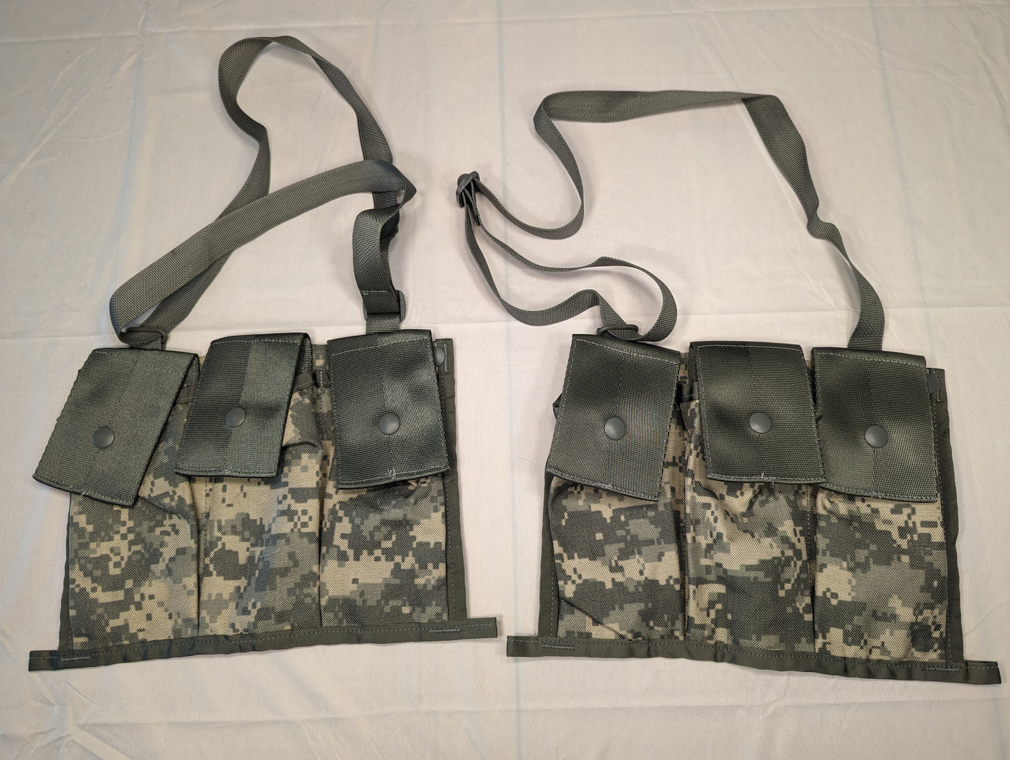 Two U.S. Military Surplus MOLLE II Bandoleers in ACU digital camouflage, laid flat side-by-side. Each bandoleer features three vertical pockets with snap closures for holding ammunition magazines and an adjustable shoulder strap.