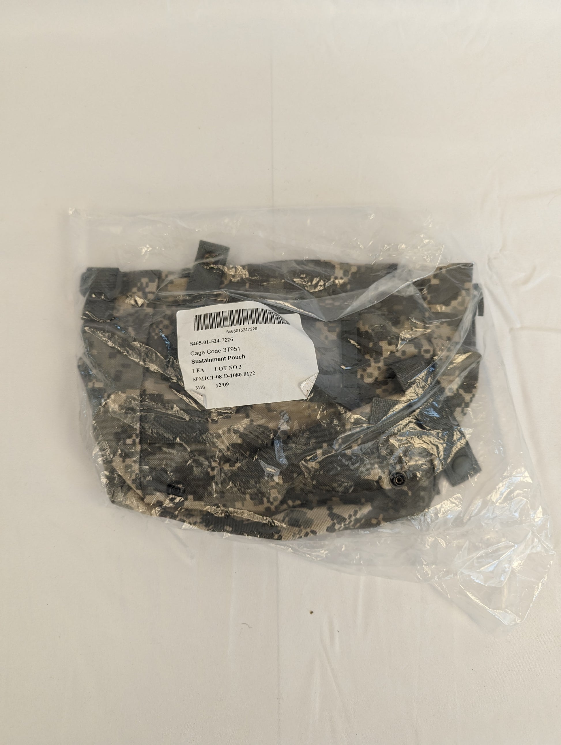 A new U.S. Military Surplus Sustainment Pouch in ACU digital camouflage, sealed inside clear plastic packaging, featuring the official issue label with 'MOLLE II' and NSN markings.