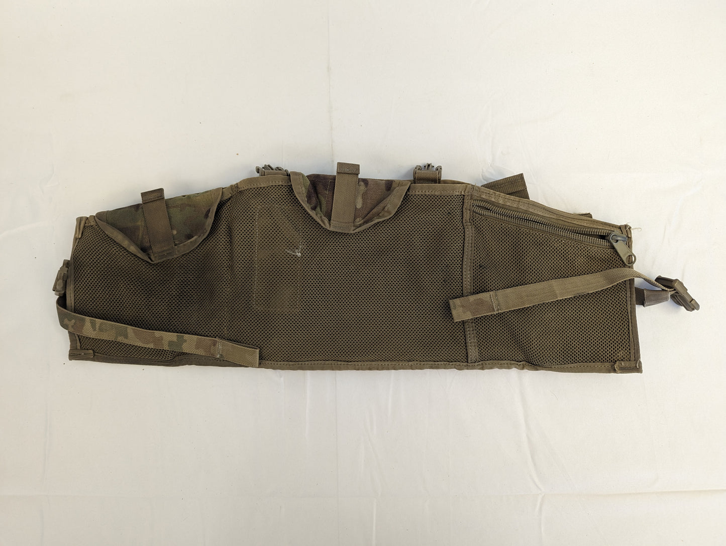 A U.S. Military Surplus Tactical Assault Panel (TAP) or Chest Rig in solid olive drab, laid flat, showcasing the full MOLLE webbing grid and the numerous strap and buckle attachment points.