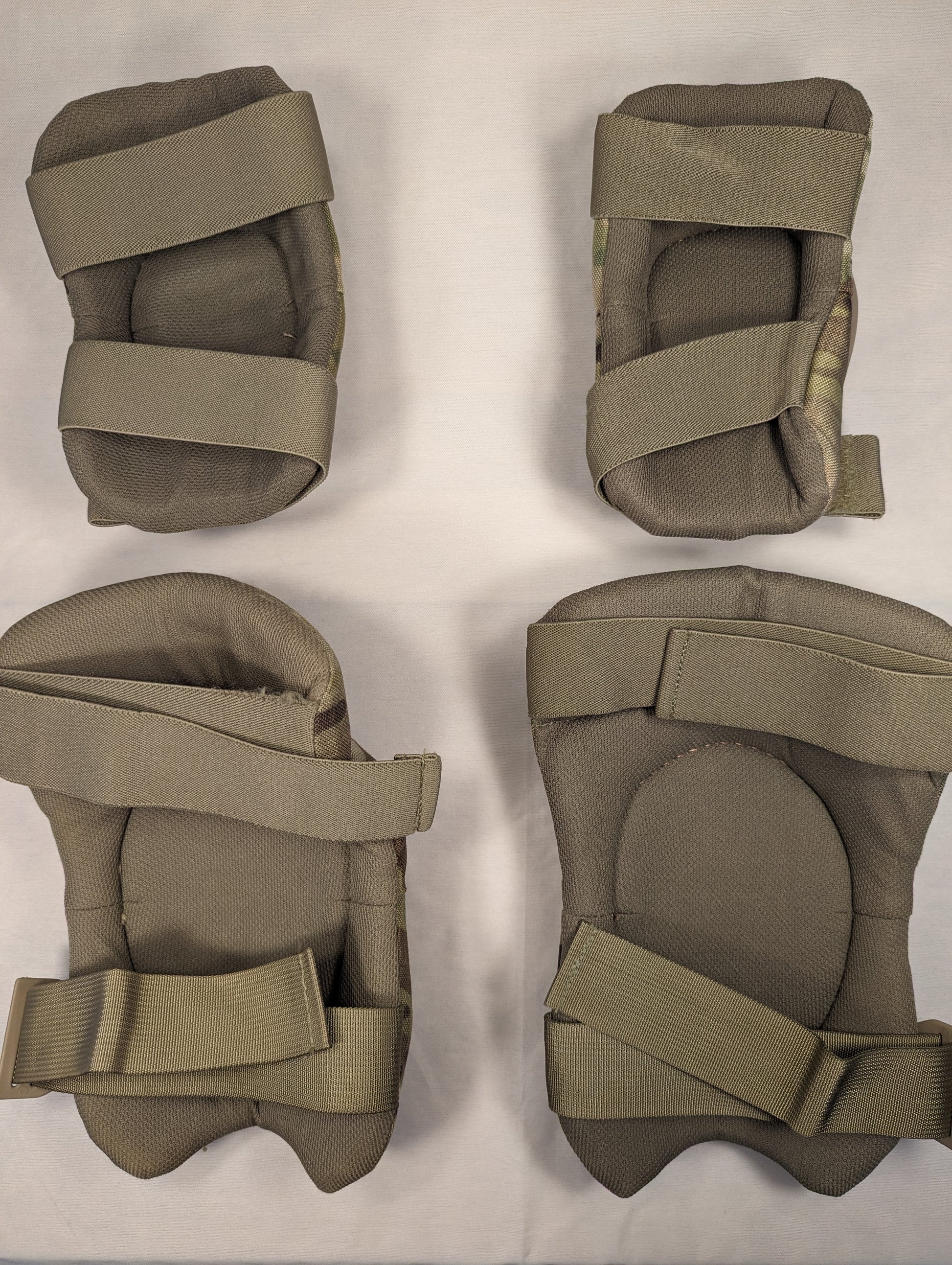 A complete set of U.S. Military tactical protective pads in OCP/Multicam camouflage, consisting of two elbow pads and two knee pads with tan hard plastic shells, laid out on a white background.