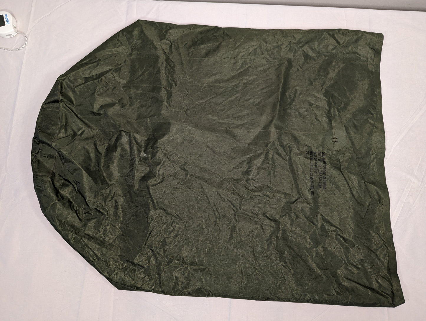 A single U.S. Military Waterproof Clothing Bag in olive green, laid flat and fully unfolded, displaying its large, rounded shape and crinkled, durable nylon fabric.