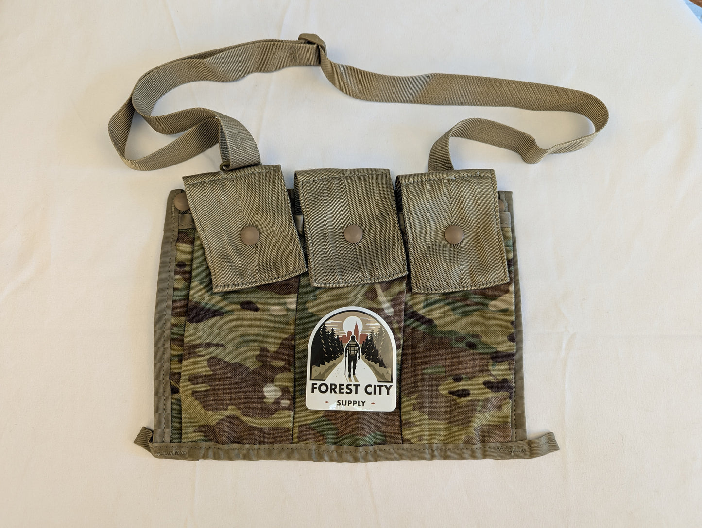 A U.S. Military Surplus OCP/Multicam Bandoleer laid flat, featuring three snap-button magazine pockets, a khaki strap, and a prominent 'FOREST CITY SUPPLY' logo sticker on the front.